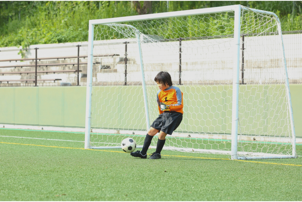 Child goalkeeper improving reflexes with hands-on goalkeeper training at 416 Soccer Club.